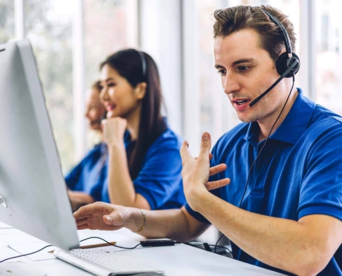 Group of happy call center smiling business operator customer support team phone services agen working and talking with headset on desktop computer at call center