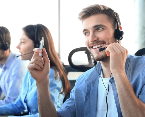 Image of a call center agent smiling on a phone call with a client.