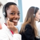 Image of a customer service person smiling on a call.