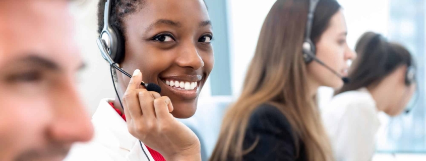 Image of a customer service person smiling on a call.