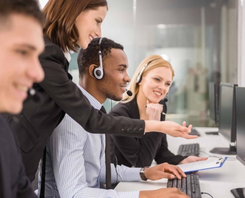 Image of a group of people assisting somebody in a call center.