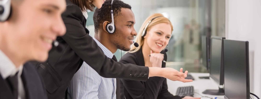 Image of a group of people assisting somebody in a call center.