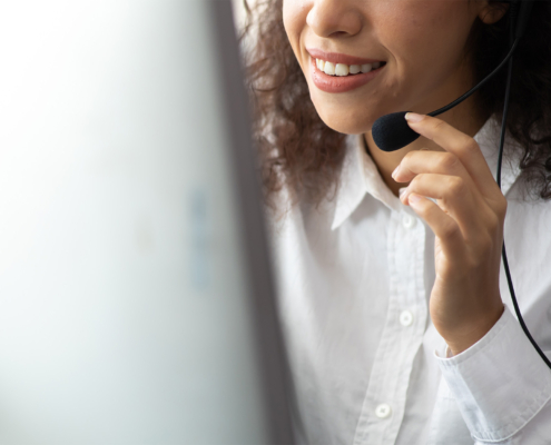 Side view of a woman with headset on talking into microphone